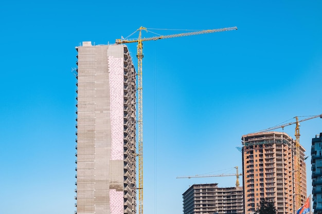 Photo building construction site with working cranes industry of housing new buildings