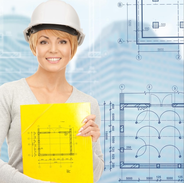 Building, developing, consrtuction, architecture concept - female contractor in white helmet with blueprint