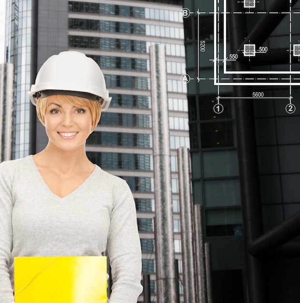 建築、開発、建設、建築コンセプト-青写真の白いヘルメットの女性請負業者