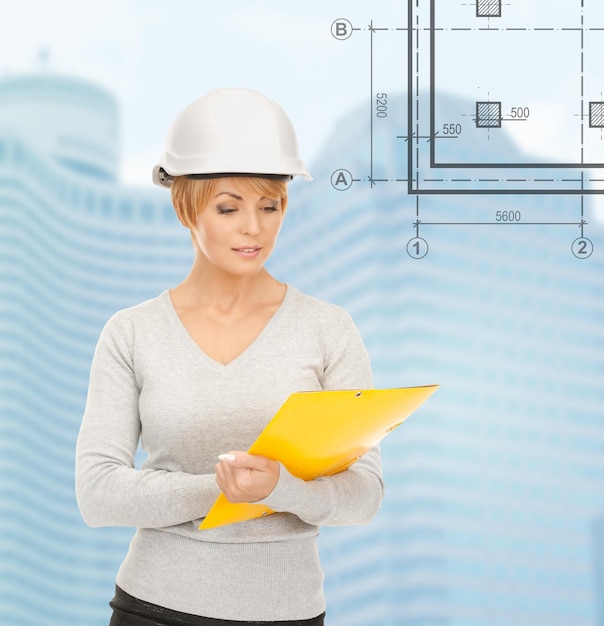 building, developing, consrtuction, architecture concept - female contractor in white helmet with blueprint