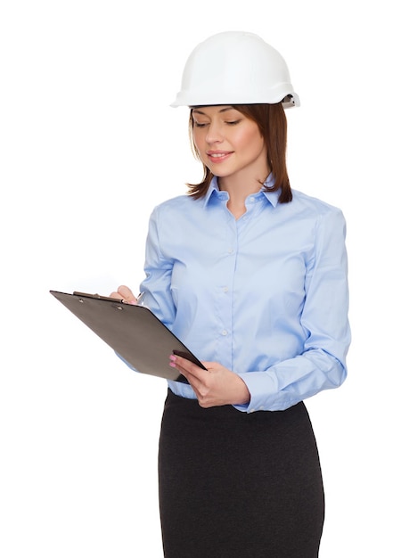 концепция строительства, разработки, строительства и архитектуры - улыбающаяся деловая женщина в белом шлеме с буфером обмена
