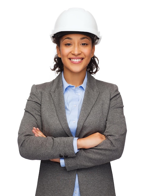 building, developing, consrtuction and architecture concept - smiling businesswoman in white helmet with crossed arms