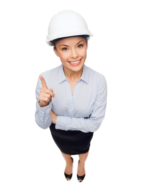 building, developing, consrtuction and architecture concept- smiling businesswoman in white helmet with finger up