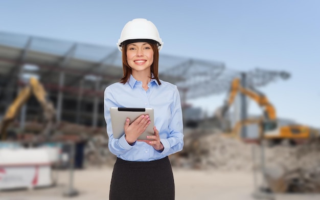 building, developing, construction and architecture concept - smiling businesswoman in white helmet ant tablet pc computer