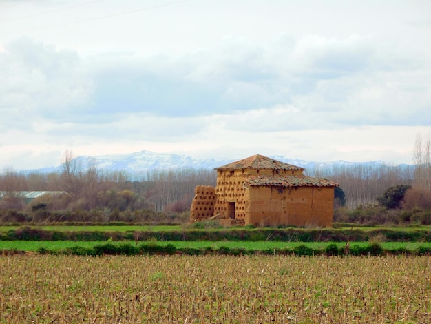 Photo a building in a field with a large structure on the side of it