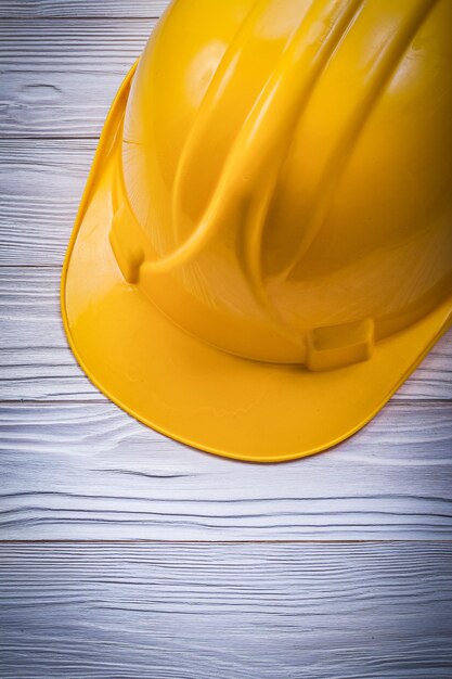 Building helmet on wooden board construction concept