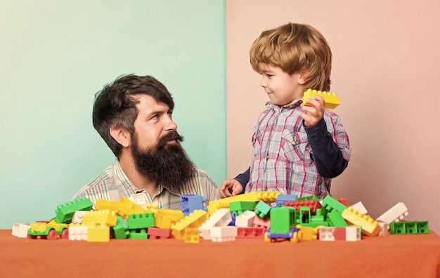 建設業者と一緒に家を建てる 子供の発達 幸せな家族 余暇の時間 父と息子がゲームをする ひげを生やした男と一緒に小さな男の子
