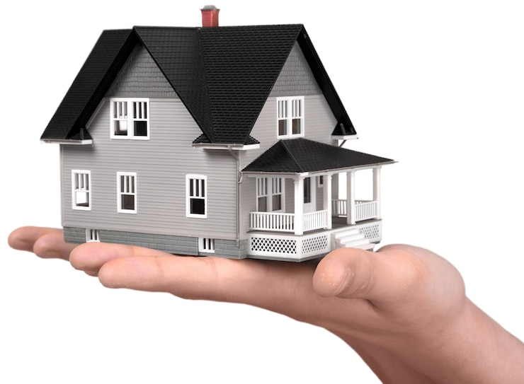 Photo building, mortgage, real estate and property concept - close up of hand holding house model