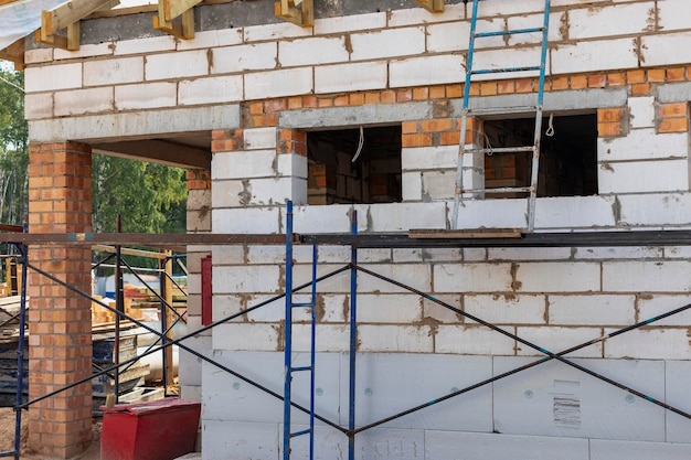Building site of a house under construction Unfinished house walls made from white aerated autoclaved concrete blocks Wooden truss system