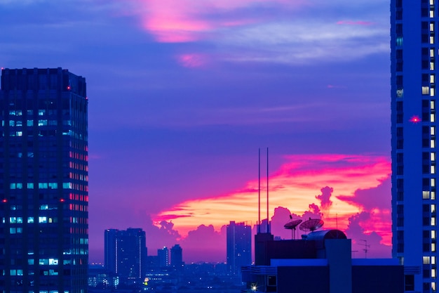 黄色の空の青紫の背景都市の風景と夕日の建物