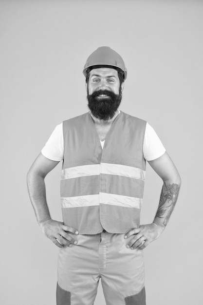 Photo building tomorrow bearded man smiling in protective workwear for building activity happy building renovation contructor on yellow background building and construction industry