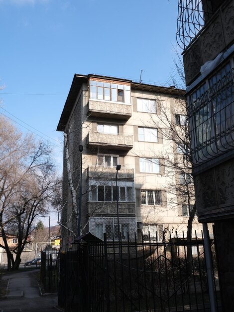 Photo a building with a balcony and a tree in the background