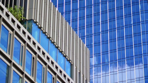 a building with a blue glass facade and a cloudy sky.