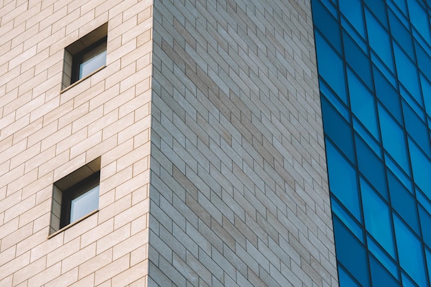 A building with a blue glass wall and a white brick building