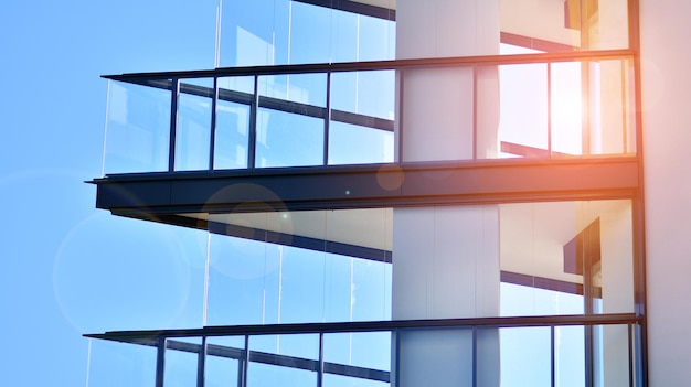 A building with a blue sky and a few windows with the sun shining through them.