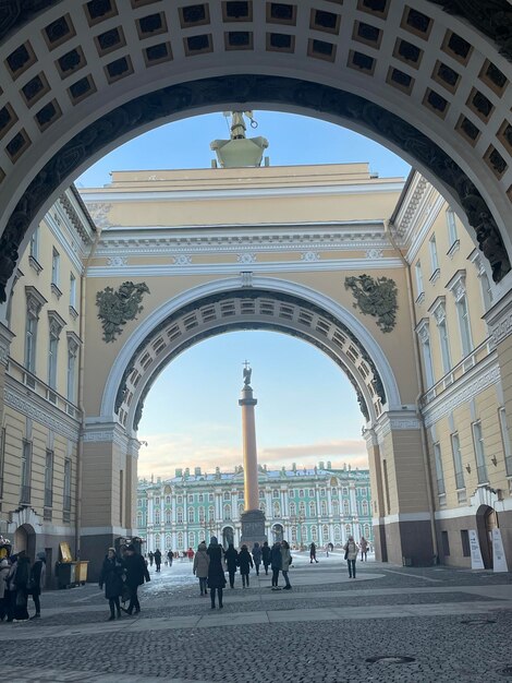 A building with a large arch and a statue of the alexander nevsky cathedral in the background.