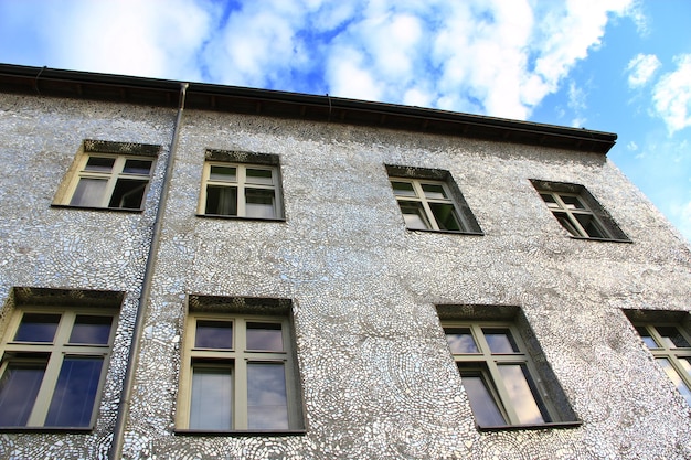 鏡張りの壁を持つ建物 鏡の破片で作られた建物のファサード 家の壁が覆われている