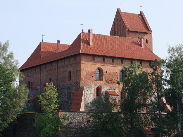 Photo a building with a red roof has a clock on the front