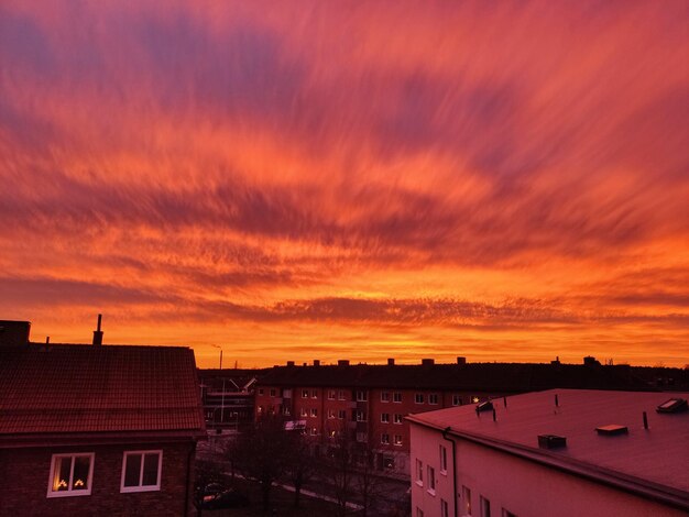 Buildings against dramatic sky during sunset