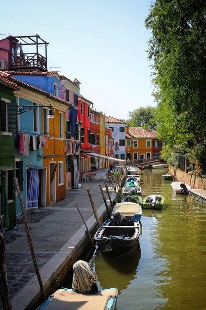 Photo buildings by canal against clear sky in city