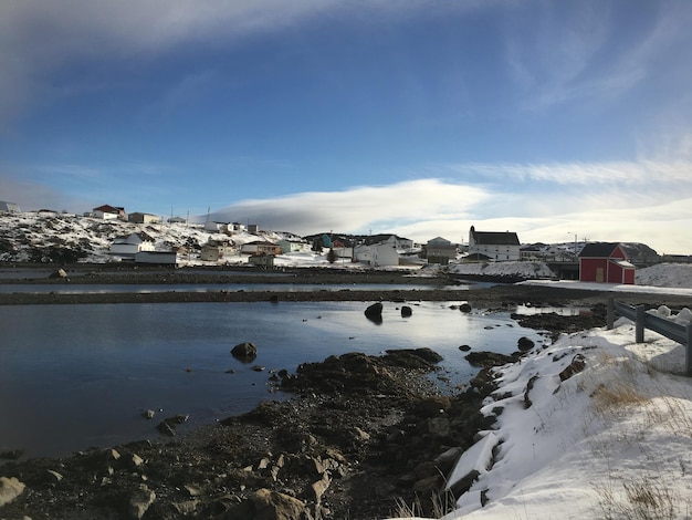 Buildings by houses against sky during winter