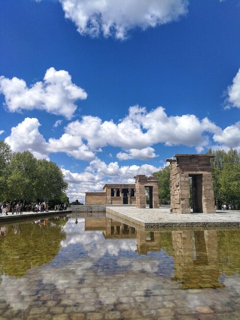 Buildings by lake against sky in city