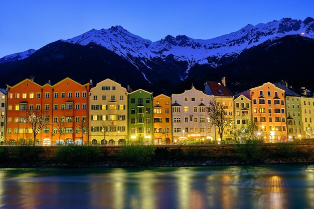 Buildings by mountains against sky at night