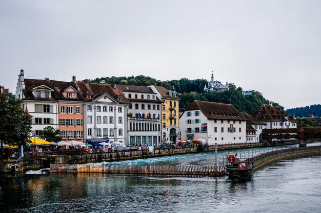 Buildings by river against clear sky