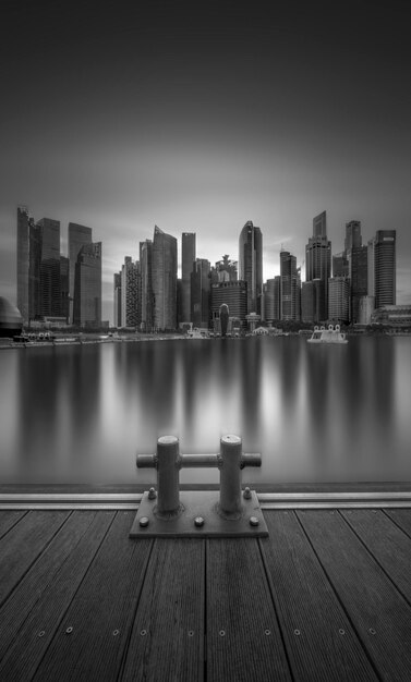 Photo buildings by river against sky in city