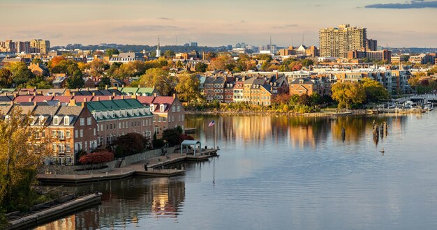 Buildings by river against sky in city