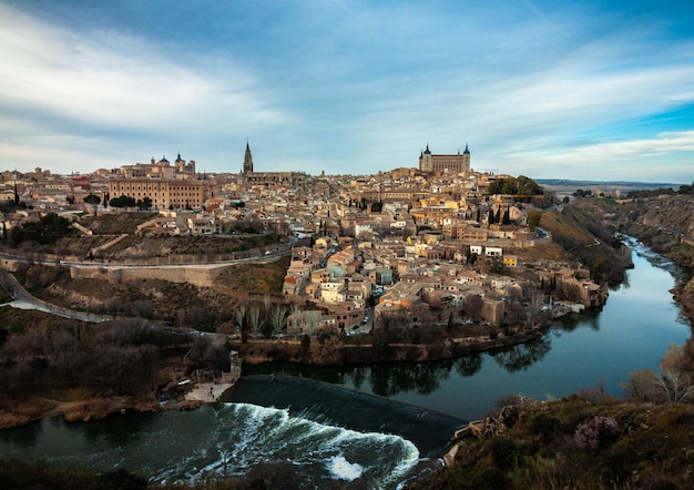 Buildings by river against sky in city