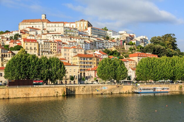 Buildings by river against sky in town