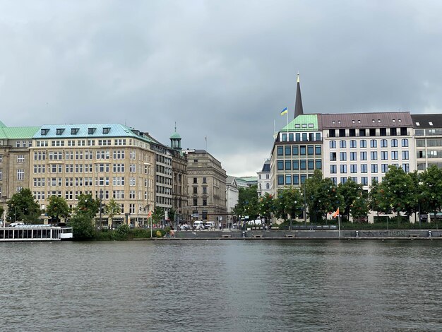 Buildings by river against sky