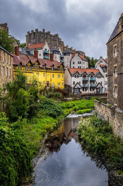 Buildings by river against sky