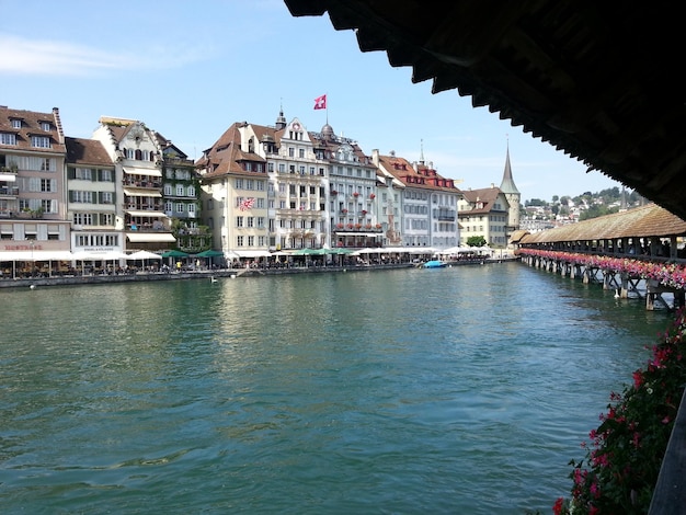 Buildings by river against sky