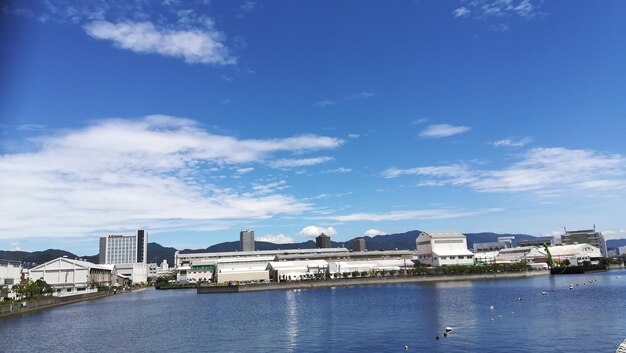 Buildings by sea against blue sky