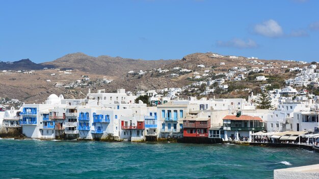 Buildings by sea against blue sky