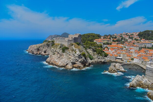 Buildings by sea against blue sky