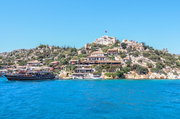 Buildings by sea against blue sky