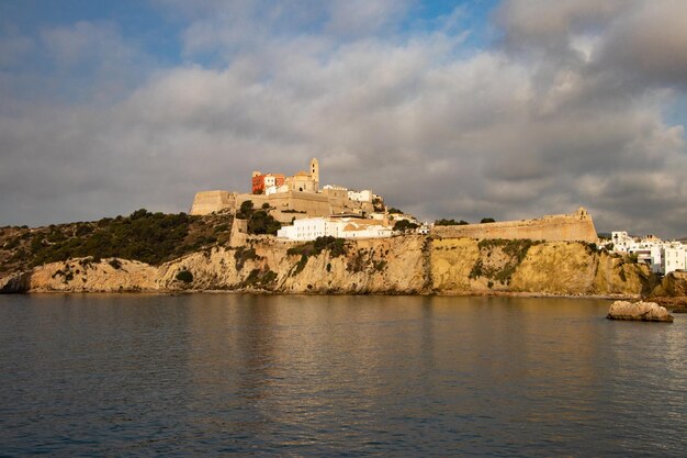 Buildings by sea against sky