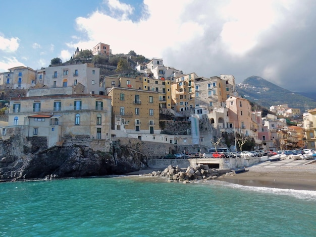 Buildings by sea against sky