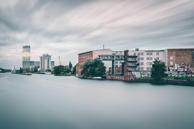 Foto edifici sul fiume contro il cielo in città