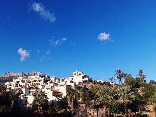 Buildings in city against blue sky