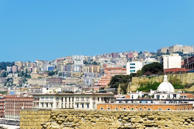 Buildings in city against clear blue sky