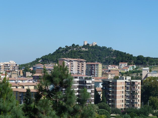 Buildings in city against clear blue sky