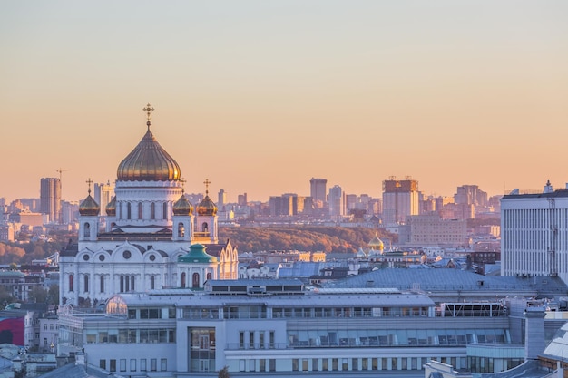 Buildings in city against clear sky during sunset