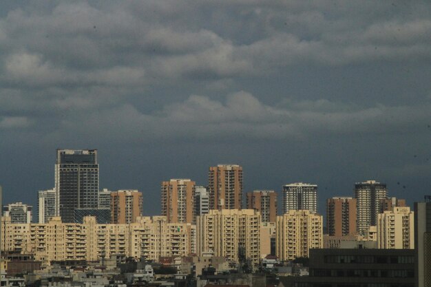 Photo buildings in city against cloudy sky gurugram haryana