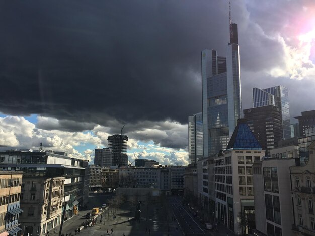 Buildings in city against cloudy sky