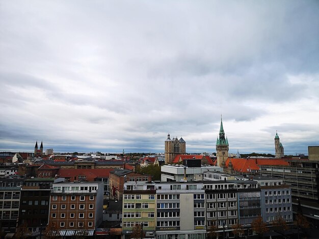 Photo buildings in city against cloudy sky