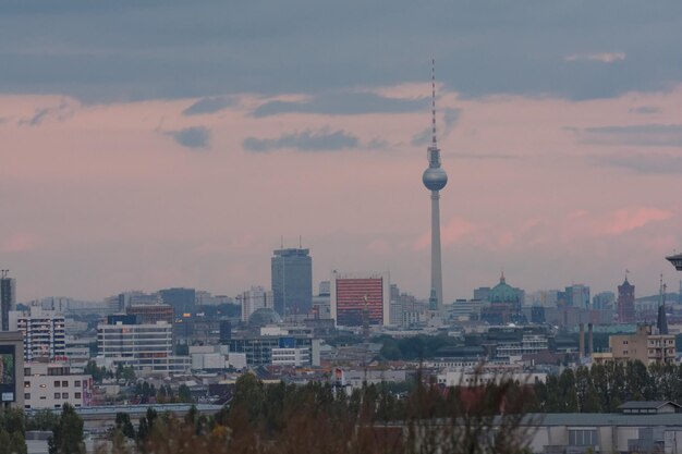 Photo buildings in city against cloudy sky